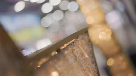 close-up of intricate gold frame illuminated by warm glowing light, featuring detailed patterns and surrounded by blurred bokeh effects