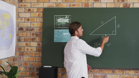 portrait of caucasian male teacher teaching mathematics in the classroom at school