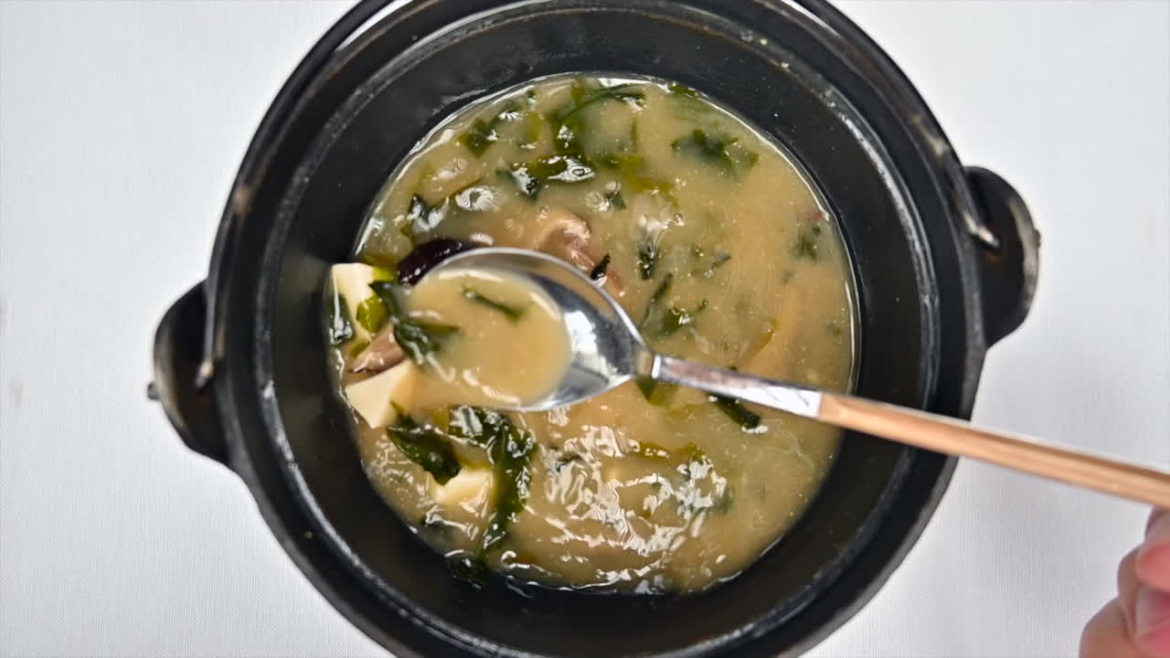 Stirring miso soup with tofu vegan cheese slow motion