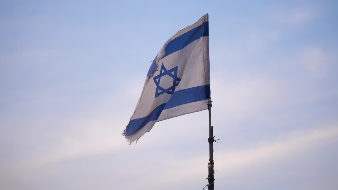 Bandiera israeliana blu e bianca issata su un'asta improvvisata sventola nella brezza