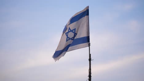 israeli blue and white flag raised on a makeshift flagpole blows in the breeze