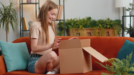 Glückliche-Junge-Käuferin-Packt-Karton-Aus,-Lieferung-Von-Paketen,-Online-Shopping-Kauf-Zu-Hause