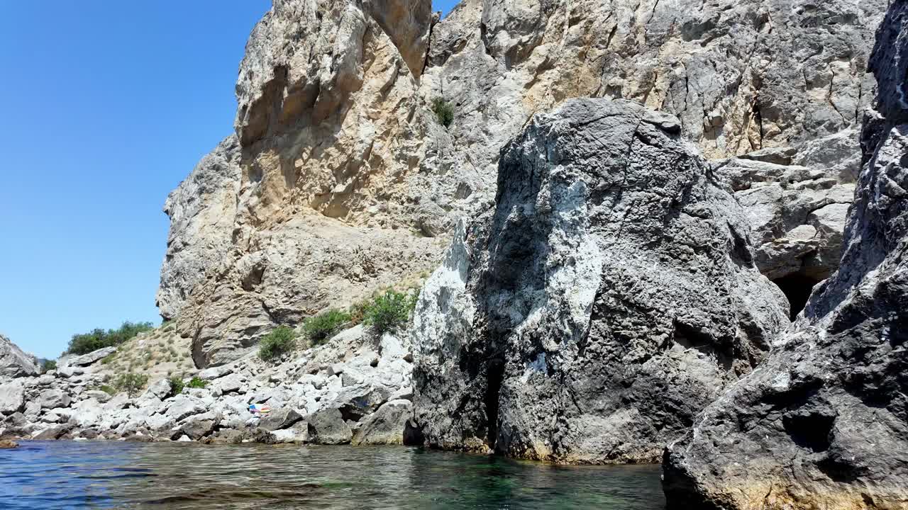 A view of the rocky coastline near Sudak, Crimea, with a small cave in the rocks