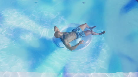 man reclining on pool float under sun, with animated health stats and hydration graphs