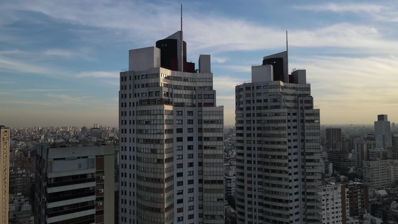 Aerial view of Twin Skyscraper Buildings in Buenos Aires and cityscape in background during golden hour
