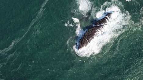 overhead view of waves crashing onto beach