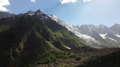 Aerial-shot-of-the-mountains-valley-and-sun-rays-coming-through-clouds-at-Naltar-Valley-in-Pakistan,-epic-drone-shot