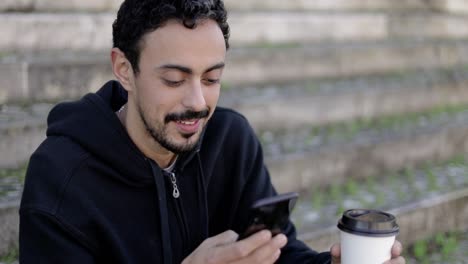 hombre de contenido con teléfono inteligente y café para llevar