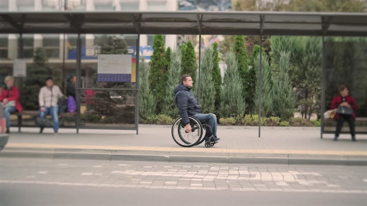 신체적 장애가 있는 사람이 접근 가능한 램프가 있는 도시 교통수단을 기다리고 있습니다.