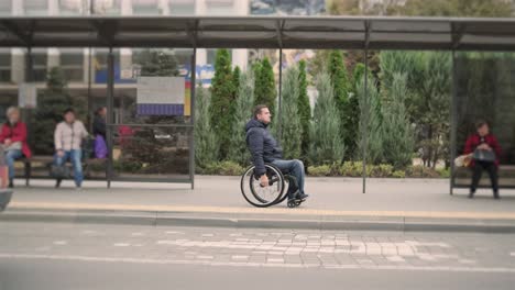 persona con discapacidad física que espera un transporte urbano con una rampa accesible