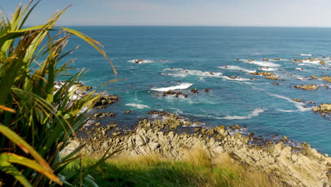 Dolly-shot-showing-beautiful-ocean-waves-crashing-against-rocks-in-New-Zealand