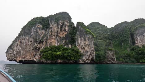 el barco se acerca a los impresionantes acantilados en krabi, tailandia.