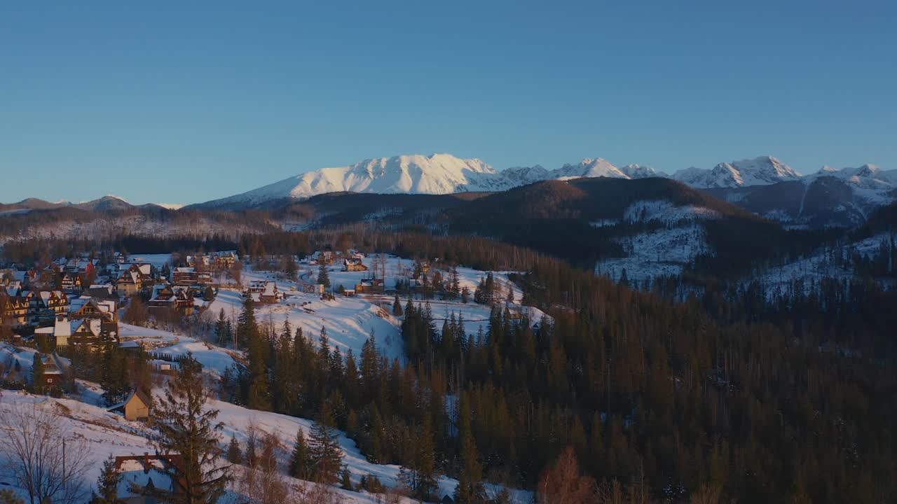 susurros de invierno: perspectiva aérea de un pueblo tradicional entre árboles forestales y montañas nevadas