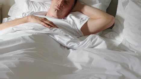 Man-sleeping-peacefully-on-bed-4k