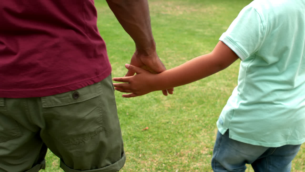 padre e hijo tomados de la mano en el jardín