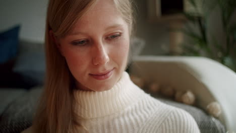 beautiful young woman enjoying a book in the living room, portrait
