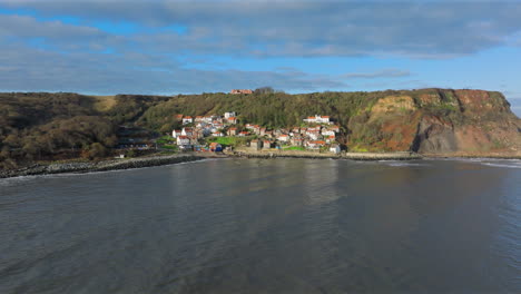 wide angle establishing drone shot approaching runswick bay village uk