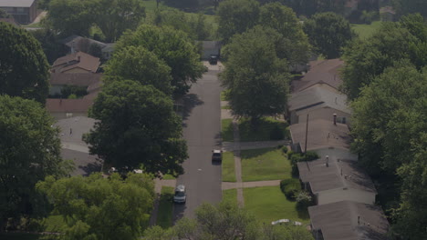 Aerial pull away down a suburban street and with ranch houses