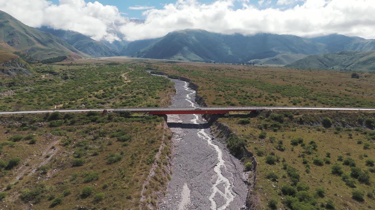 fotografía aérea que se acerca a un hermoso puente en jujuy, argentina, con un coche a toda velocidad
