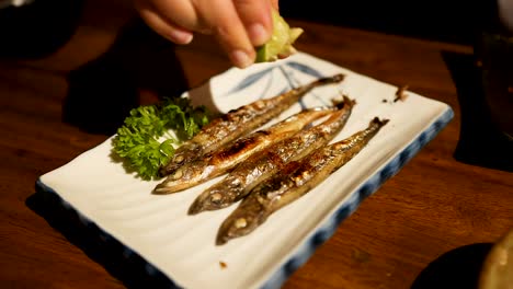 plato de pescado shishamo a la parrilla con lima exprimida