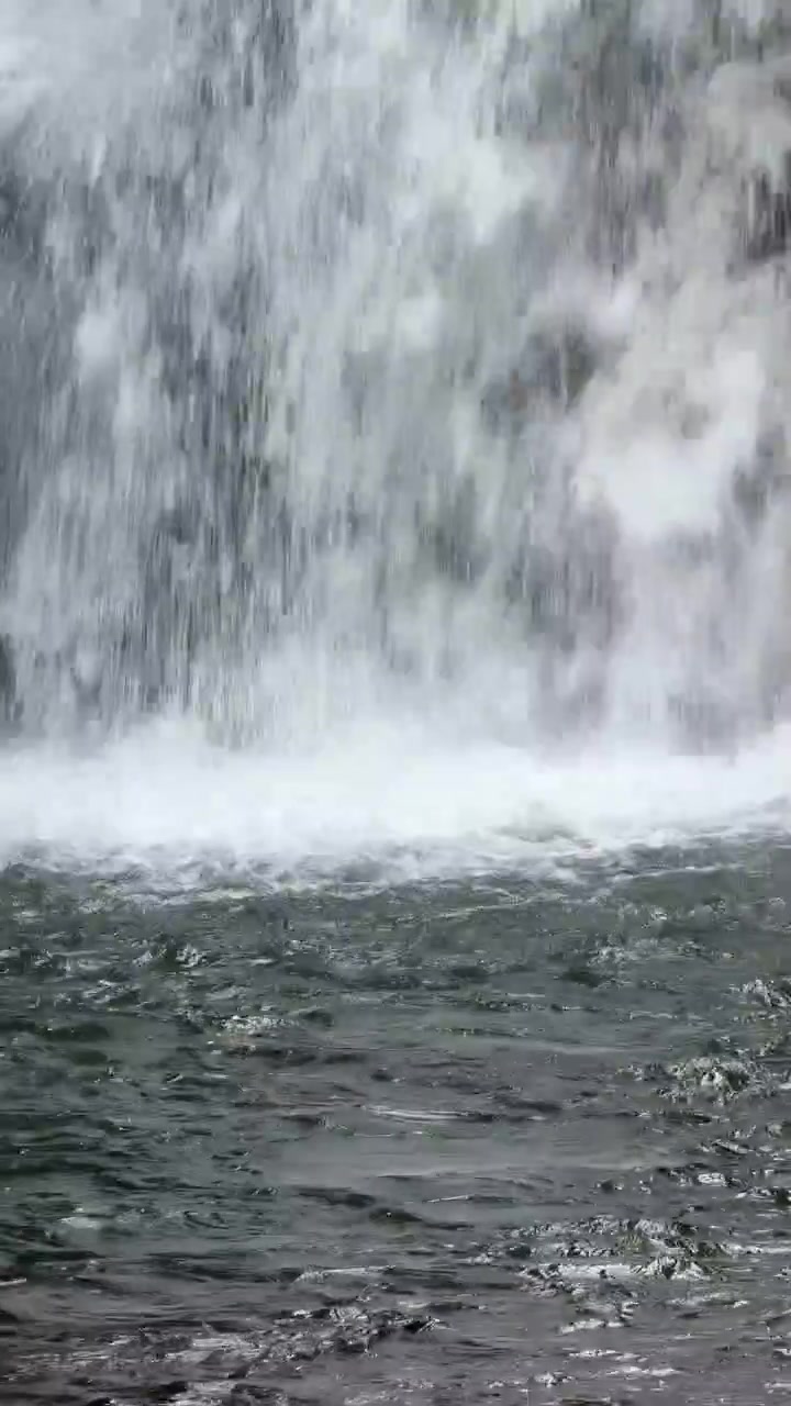 Primo piano di acqua che scende a cascata da una cascata in una pozza