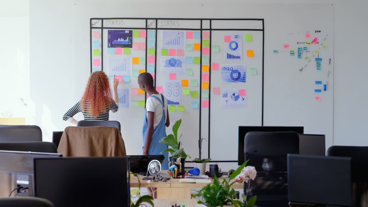 Rear view of young cool mixed-race business team planning and working in a modern office 4k