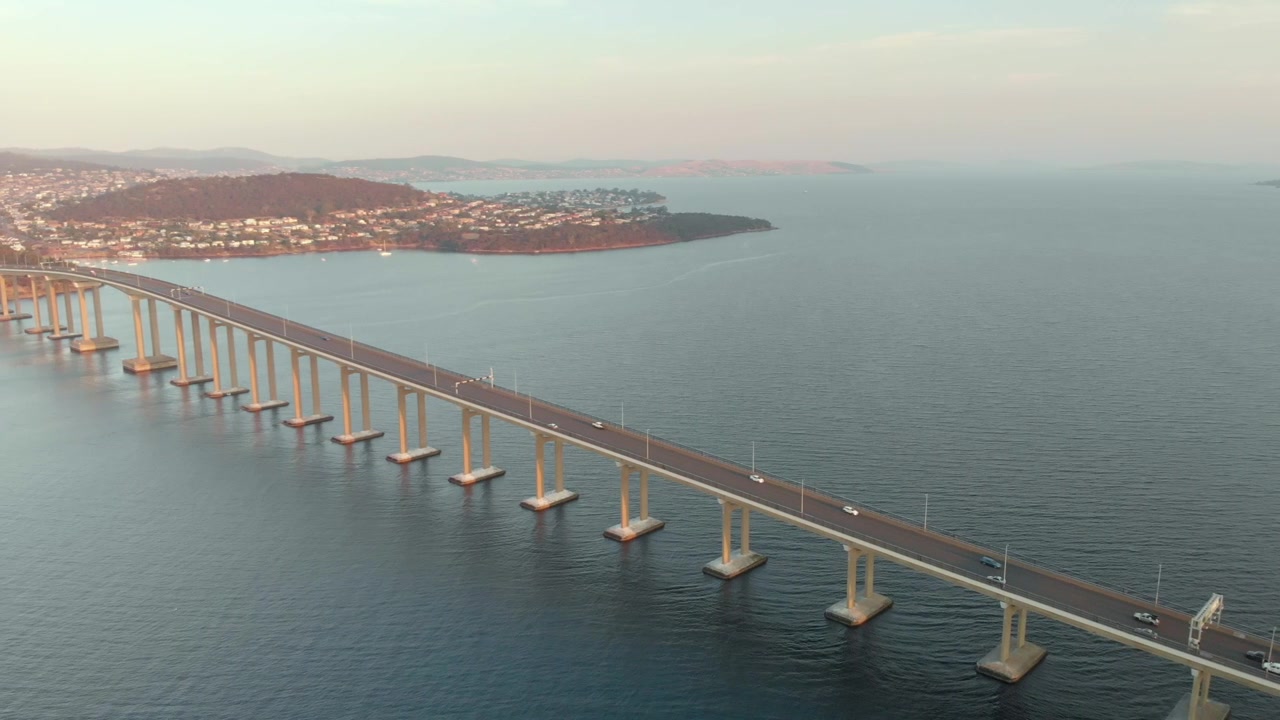 Ripresa aerea sull'autostrada del ponte Tasman al tramonto. (Filmato da drone)