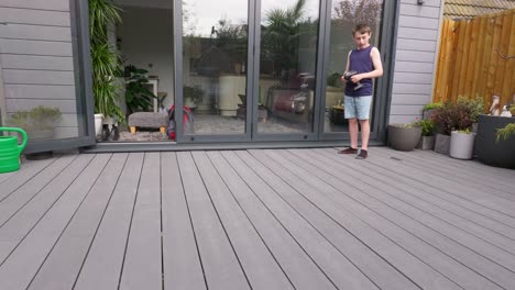 young boy at home outdoors in the garden playing with his rc car, truck, 4 x 4