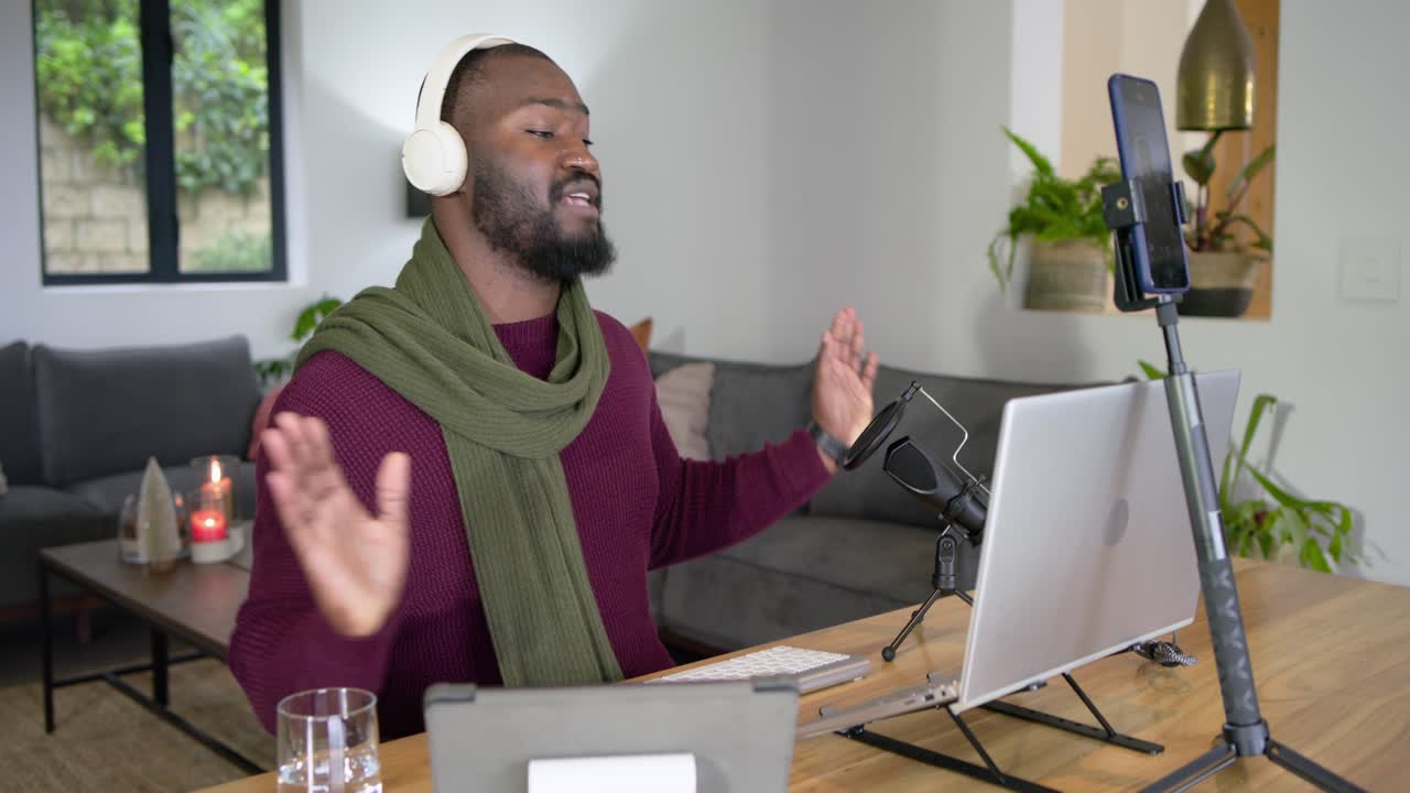 African American man greeting participants upon session start, using microphone, checking tablet
