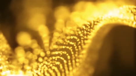 shimmering golden particles glide and twirl in a dark environment, creating captivating fluid motion and enchanting visual effects that inspire wonder and creativity.