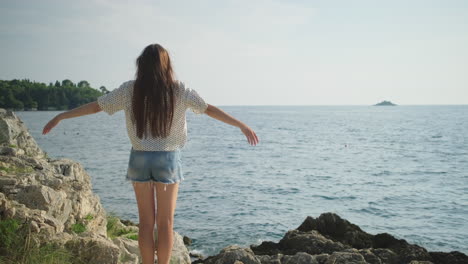 mujer disfrutando de la vista en la orilla del mar