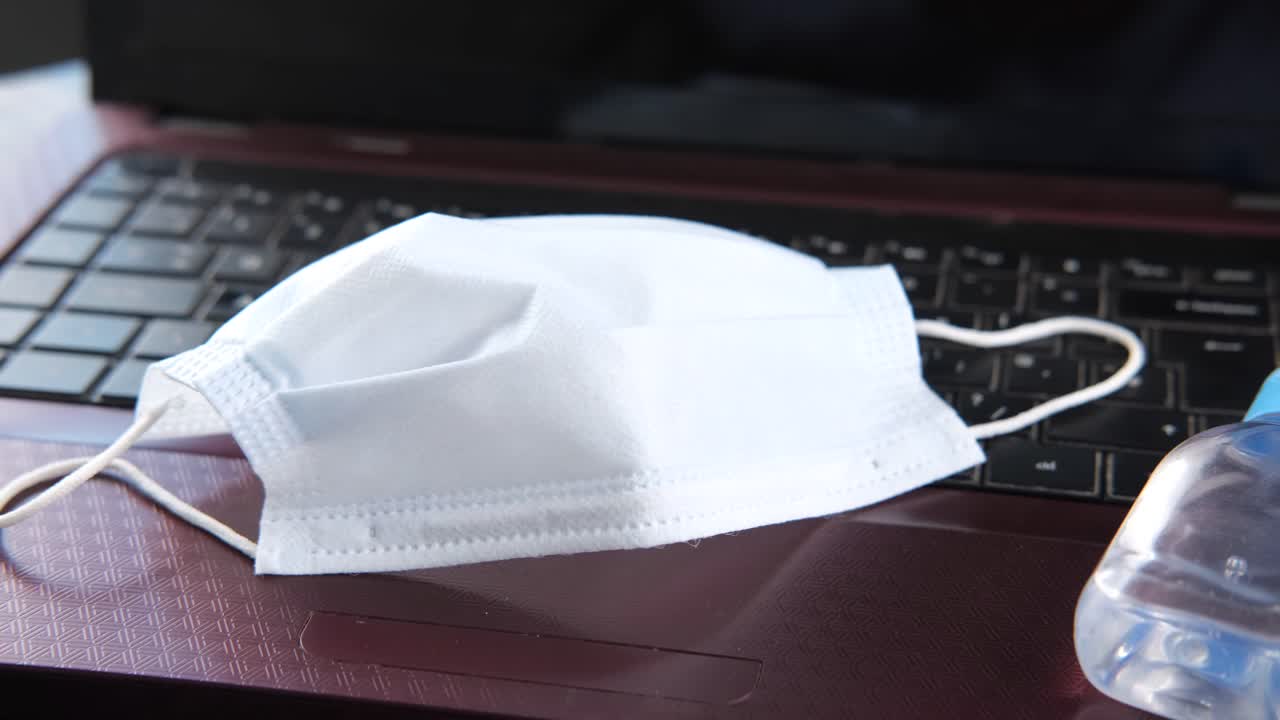 얼굴 마스크와 손 위생제와 함께 노트북