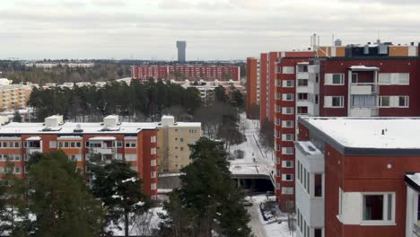 Snowy-Winter-Scene,-Aerial-Flypast-Red-High-Rise-Apartments-Stockholm