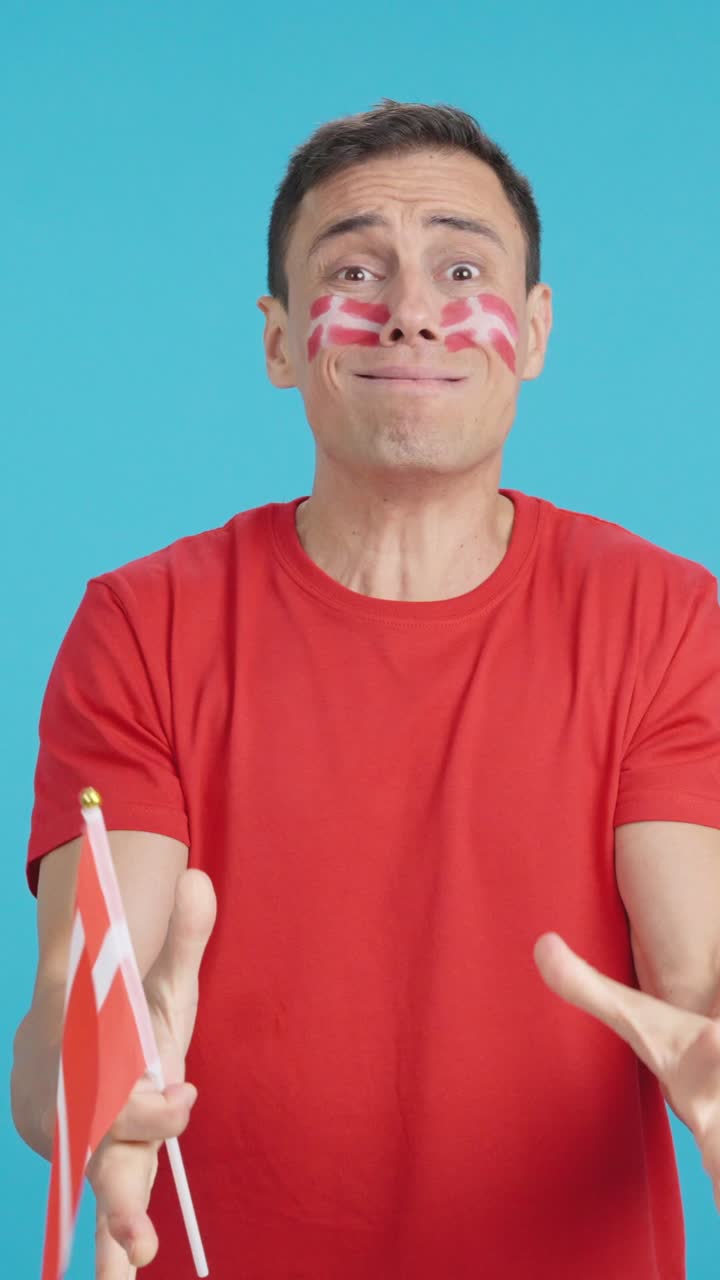 Man cheering for Denmark during a match that is lost