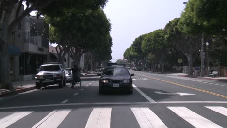 a car travels along a street in santa monica california as seen through the rear window