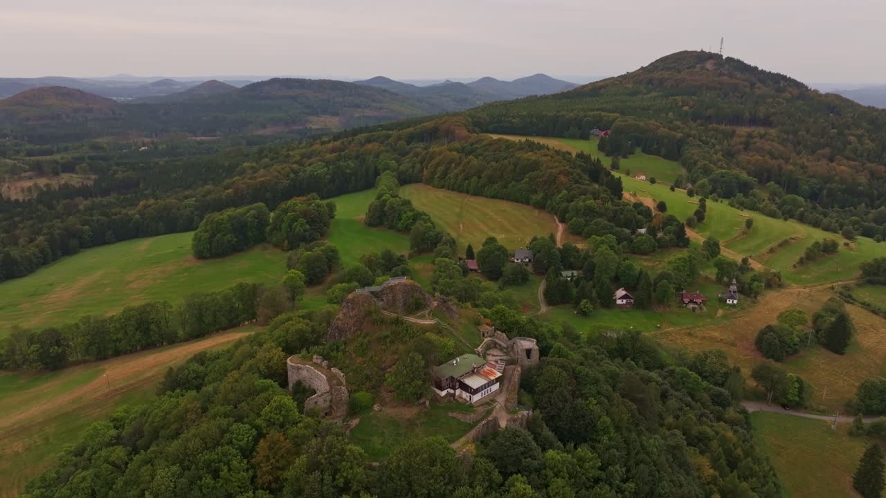 Luftfoto af slotsruiner i farverig efterårsskov, Tjekkiet