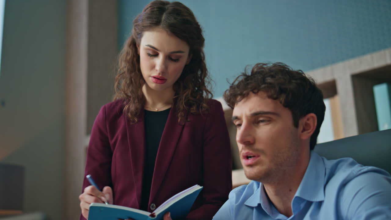 Trainee writing mentor instructions in copybook standing office place close up.