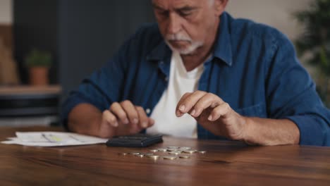 caucasian senior man counting home budget using calculator.