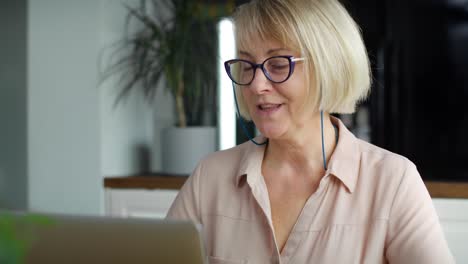 Close-up-video-of-senior-woman-using-laptop-at-home