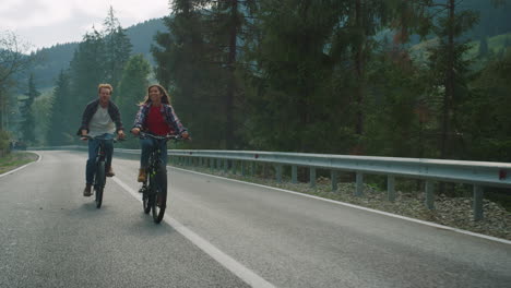 lovers cycling mountain bikes on nature road. happy couple enjoy sport activity.