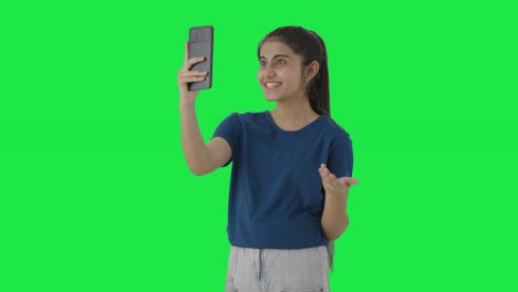 Happy-Indian-teenage-girl-talking-to-someone-on-video-call-Green-screen