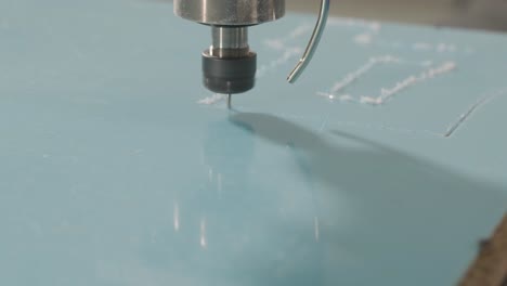 máquina de corte cnc en el trabajo, corte de hojas de plástico acrílico. producción de carteles publicitarios