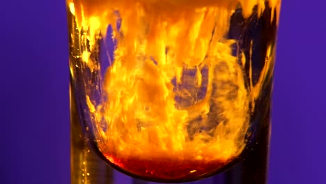 colorful layered drink experiment in a shot glass