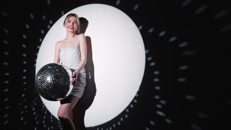 woman holding disco ball in a spotlight