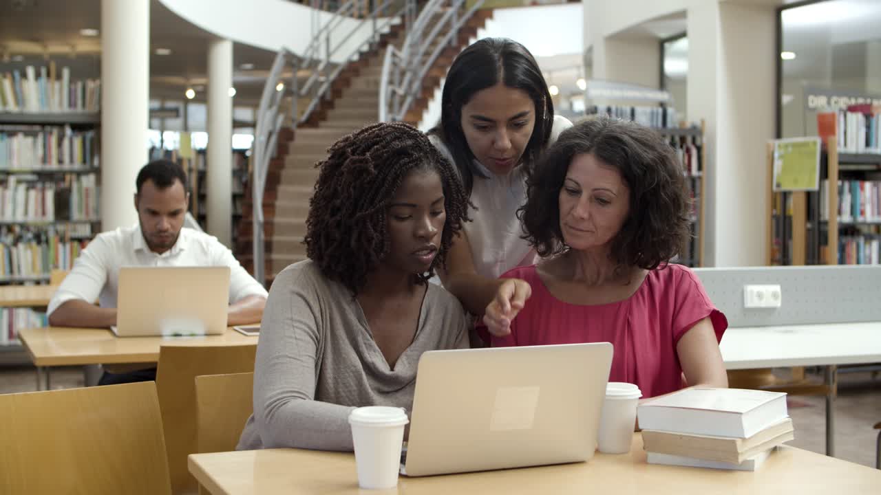 vista frontal de mujeres serias que trabajan en la biblioteca