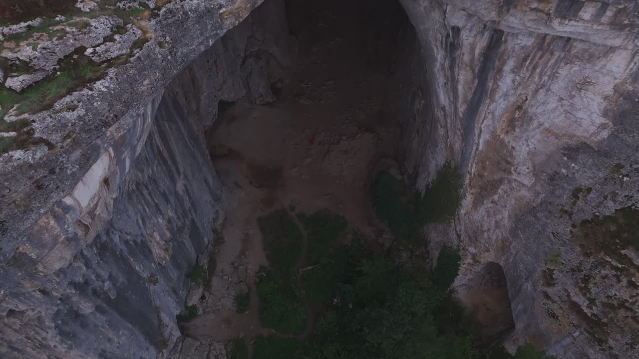 Vista aerea con drone della Grotta di Prohodna con nebbia e colline verdi, Karlukovo, Bulgaria