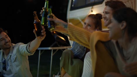 group of young friends spending time on the camping side at night.