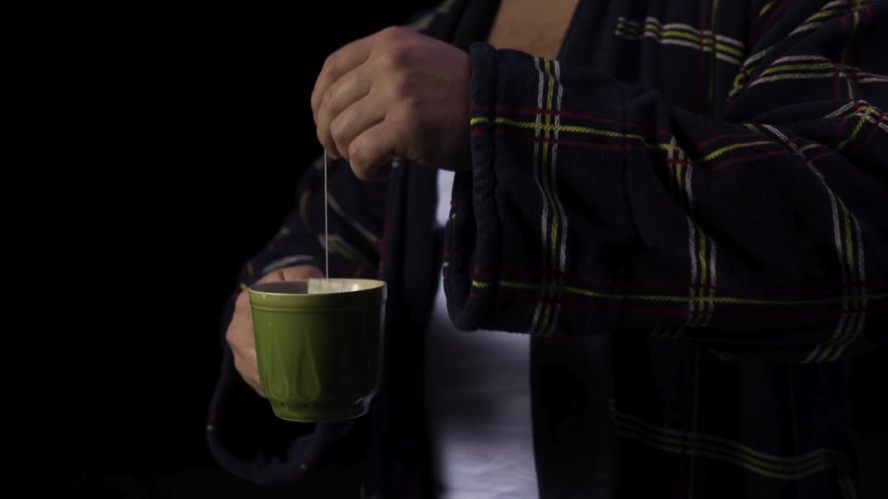 카레드 로브 를 입은 남자 가 차 를 마시고 있다