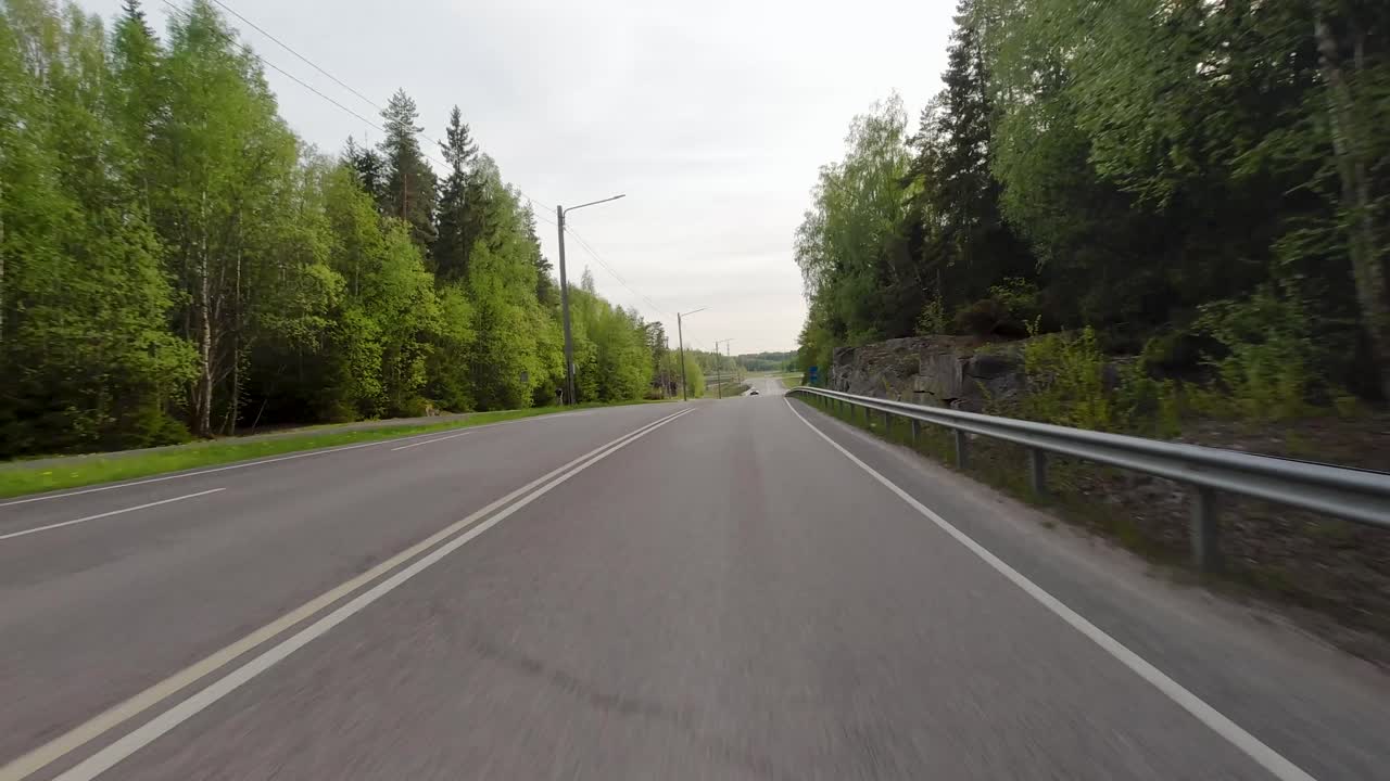 도로 를 둘러싸고 있는 활기찬 초록색 나무 들 의 광경 은 주변 환경 에 자연적 인 아름다움 과 평온 함 을 더 한다