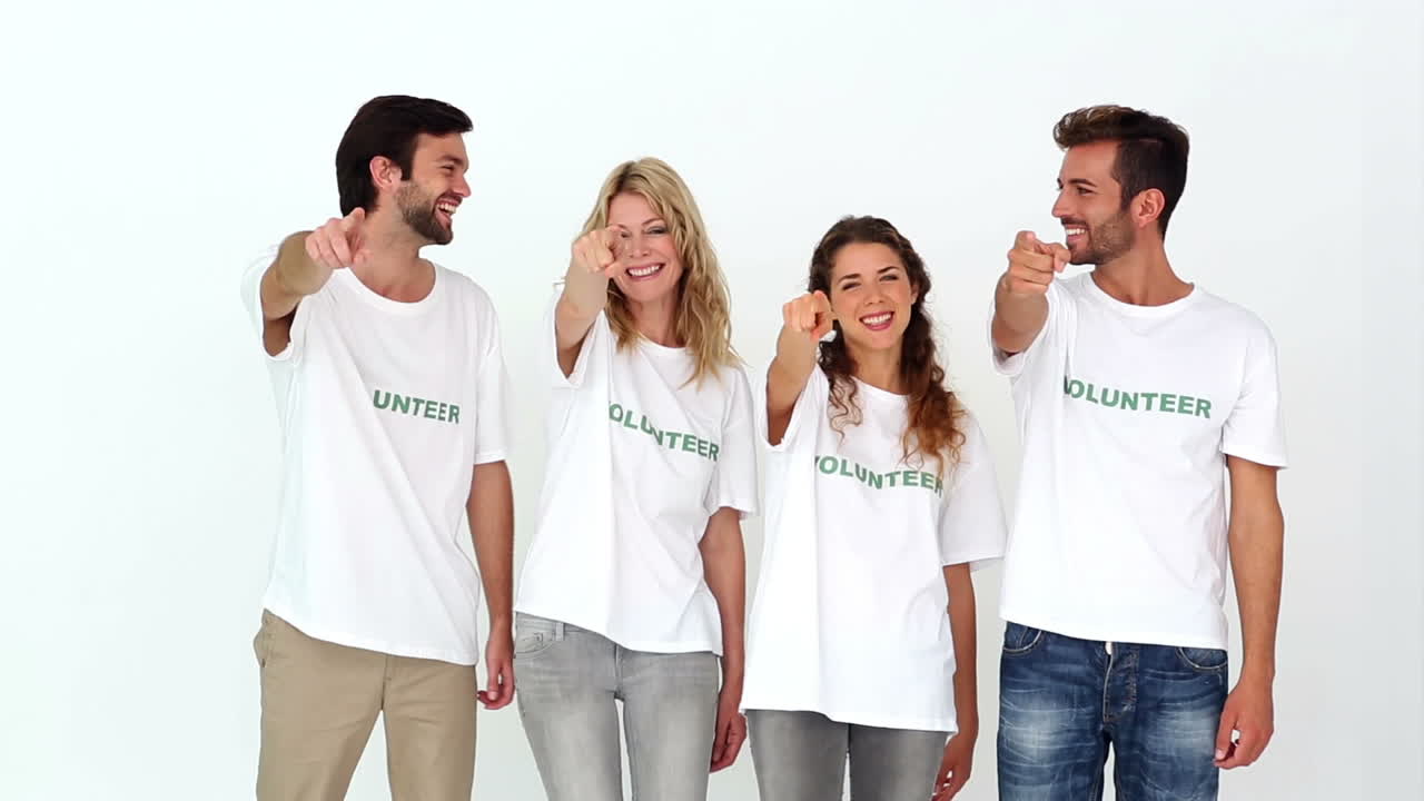 Tým dobrovolníků se usmívá do kamery a ukazuje palce nahoru.